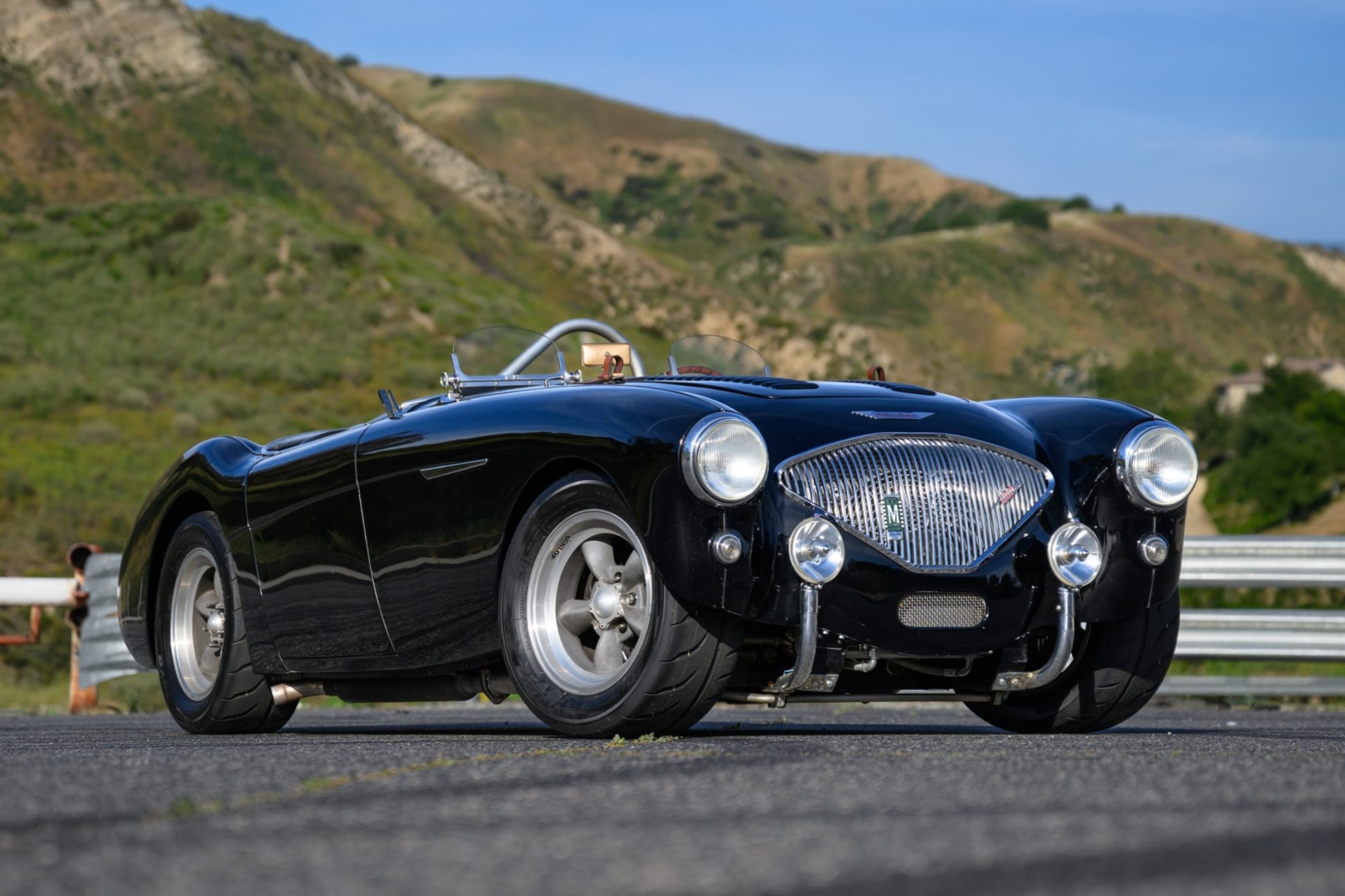 1955 Austin-Healey 100 — black sports car on mountain road